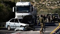 Israeli security forces examine the scene of a Palestinian shooting attack, near Wadi al-Haramiya, West Bank, Sunday, Jan. 7, 2024.