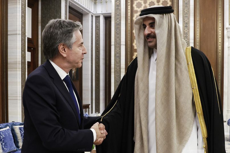 U.S. Secretary of State Antony Blinken, left, shakes hands with Qatar's Emir Sheikh Tamim Bin Hamad Al Thani.