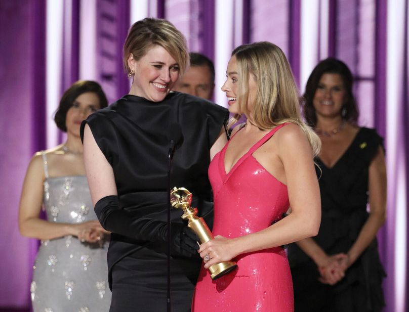 Greta Gerwig, left, and actor Margot Robbie accepting the award for best cinematic and box office achievement for the film "Barbie" during the 81st Annual Golden Globe Awards