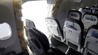 This photo released by the National Transportation Safety Board shows a gaping hole where the paneled-over door had been at the fuselage plug area of Alaska Airlines Flight.