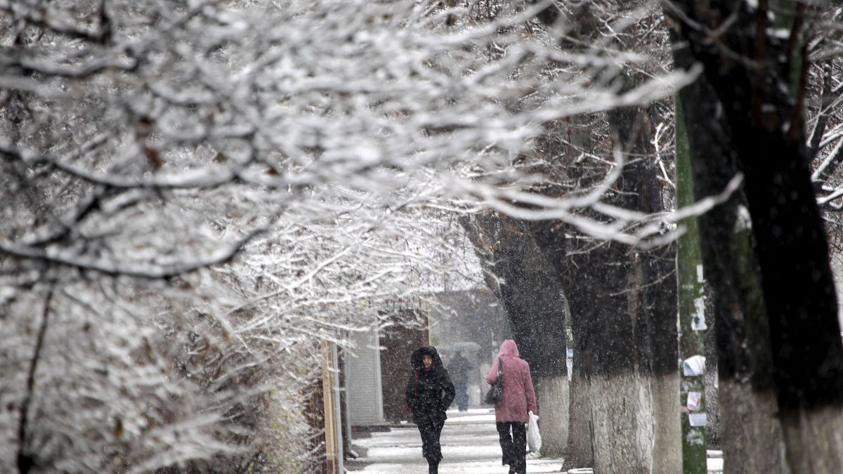 مواطنون يسيرون في العاصمة المولدوفية كيشيناو، مع تساقط الثلوج لأول مرة هذا العام يوم السبت 27 نوفمبر 2010