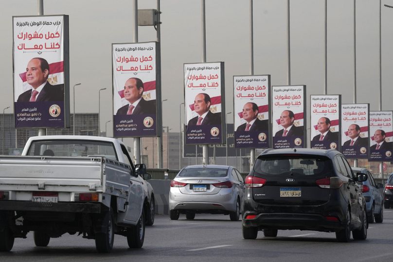 Vehicles pass near banners supporting Egyptian President Abdel Fattah el-Sissi for the presidential elections, in Cairo, December 2023