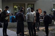 FILE - Dozens of people from all over the world line in front of the central registration center for asylum seekers in Berlin, Germany, Monday, Sept. 25, 2023.