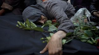 Palestinesi piangono i parenti uccisi dai bombardamenti israeliani sulla Striscia di Gaza davanti a un obitorio di Khan Younis, domenica 24 dicembre 2023.