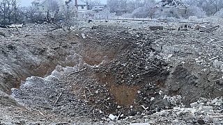 a crater of an explosion is seen next to the private building destroyed after a Russian missile attack in Novomoskovsk, near Kryvyi Rih, Ukraine, Monday, Jan. 8, 2024. 
