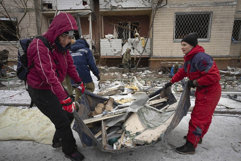 Volunteers and residents clear the debris of an apartment building heavily damaged after Tuesday's Russian missile attack in Kyiv, Ukraine, Wednesday, Jan. 3, 2024.