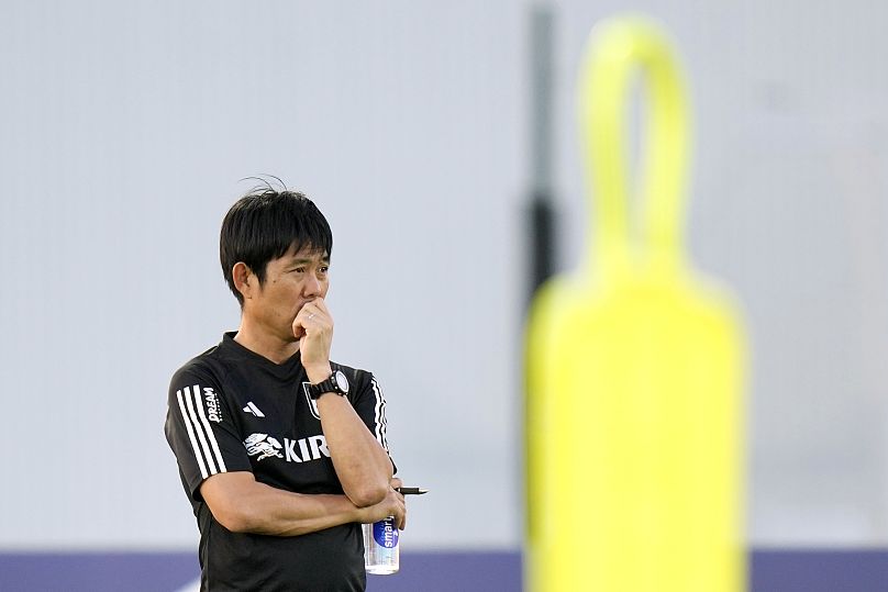 Japan's head coach Hajime Moriyasu looks at his players warming up during a training session of Japan national team in Doha