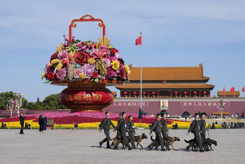 Security officials walk with dogs in Tiananmen Square during the opening ceremony of the Belt and Road Forum in Beijing, October 2023