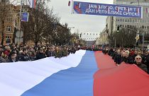 Bosnian Serbs march carrying a giant Serbian flag during a ceremony on the occasion of "the day of Republika Srpska" in the Bosnian town of Banja Luka in 2022.