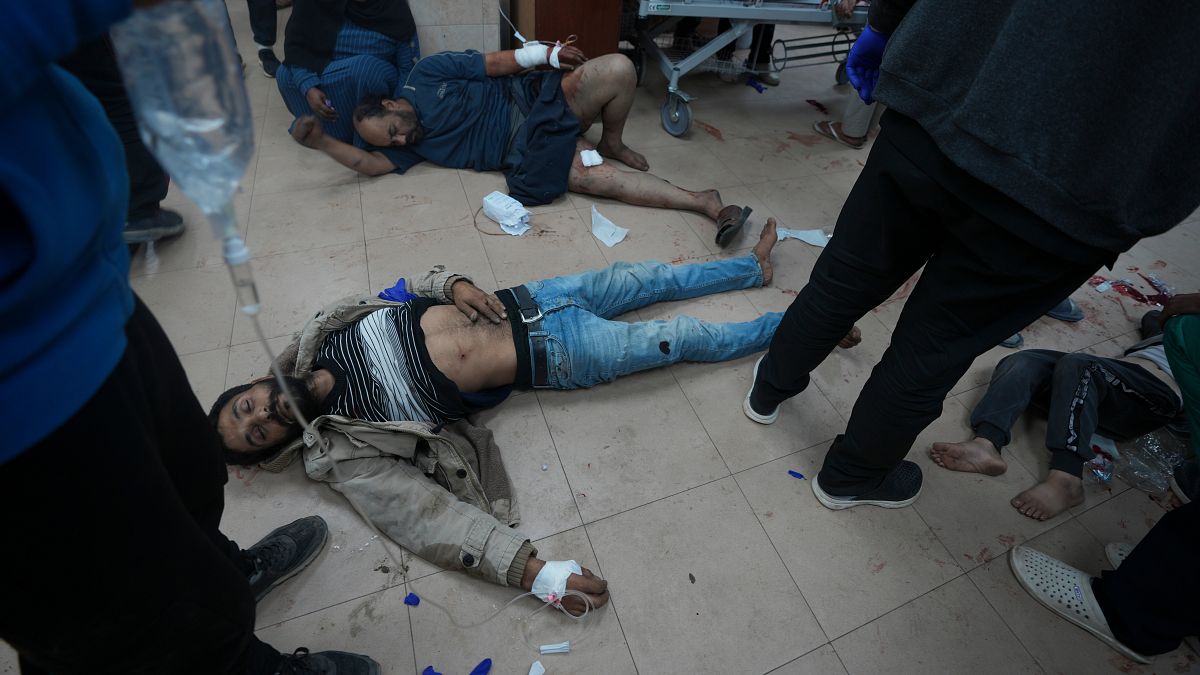 أشخاص مصابون إثر قصف إسرائيلي ملقون على الأرض في مستشفى "شهداء الأقصى" في دير البلح