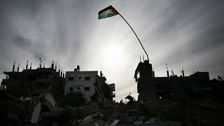 العلم الفلسطيني يرفرف فوق المباني المدمرة في جباليا، قطاع غزة. 