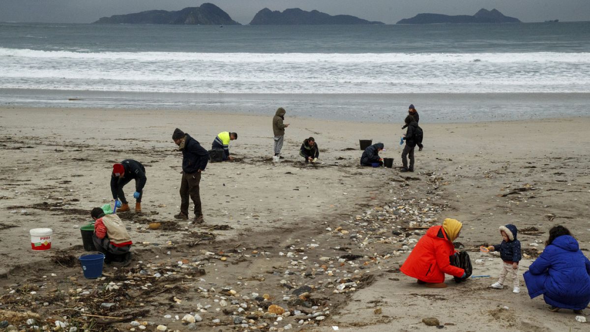 Des volontaires ramassent des billes de plastique sur une plage de Nigran, Pontevedra, Espagne, mardi 9 janvier 2024.