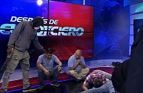 This screen grab of live video from the TC Television network shows a masked, armed person standing over journalists during a live broadcast, in Guayaquil, Ecuador, 9/1/24.