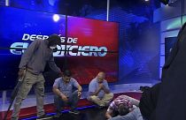 Una persona armada y enmascarada de pie junto a periodistas durante una transmisión en vivo, en Guayaquil, Ecuador, el martes 9 de enero de 2024.