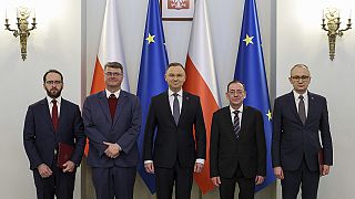 Poland's President Andrzej Duda, center, poses with new adviser Stanislaw Zaryn, far left, former deputy interior minister Maciej Wasik.