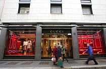 People walk in front of Gucci shop in Monte Napoleone street in Milan, Italy, Thursday, Oct. 20, 2016.