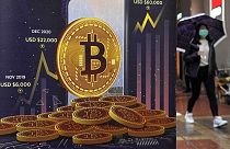 An advertisement for Bitcoin cryptocurrency is displayed on a street in Hong Kong.