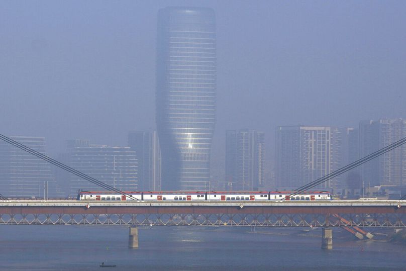 A train crosses the New Railroad Bridge, over the Sava river on the Belgrade-Novi Sad high-speed railway during a foggy day in Belgrade, October 2022