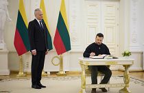  Lithuania's President Gitanas Nauseda, left, looks on as Ukrainian President Volodymyr Zelenskyy signs the guest book during their meeting in Vilnius, Lithuania, Jan. 10 2024