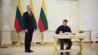  Lithuania's President Gitanas Nauseda, left, looks on as Ukrainian President Volodymyr Zelenskyy signs the guest book during their meeting in Vilnius, Lithuania, Jan. 10 2024