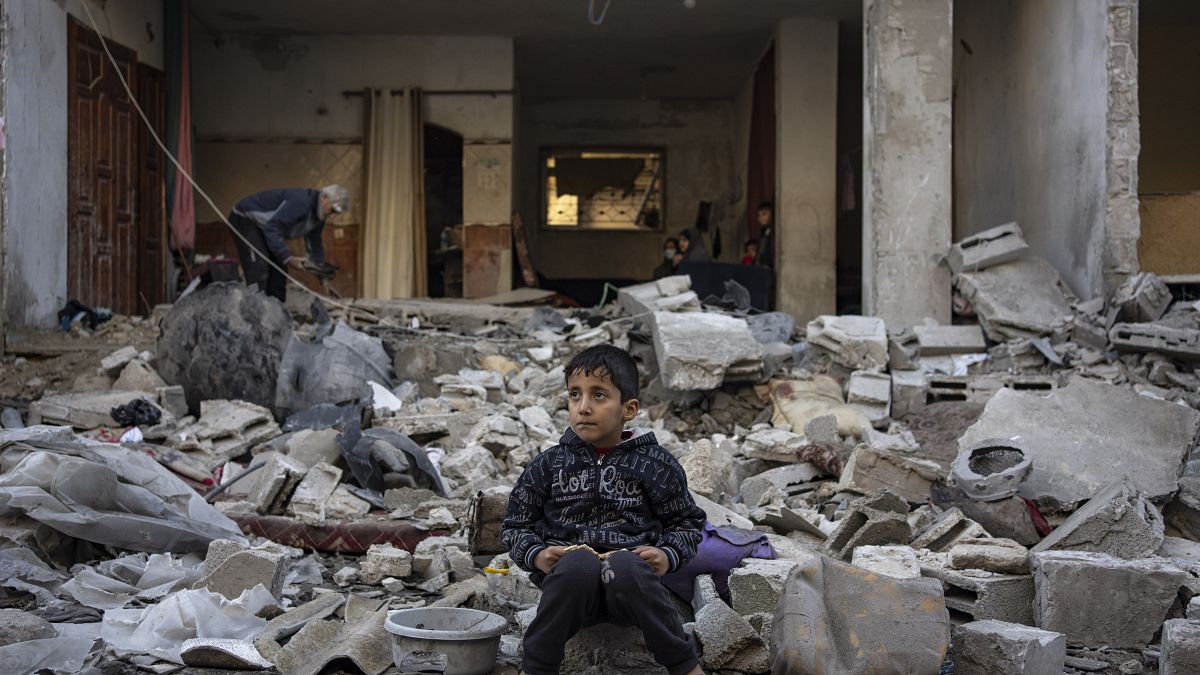 طفل يجلس على أنقاض بيته المهدم في غزة
