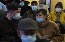 People wearing face masks as a precaution wait for a doctor appointment inside a hospital in Barcelona.