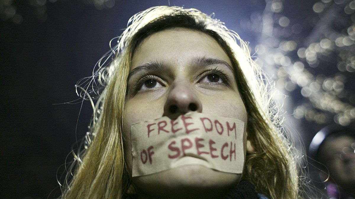 سيدة تلصق ورقة مكتوب عليها حرية التعبير، في صربيا. 