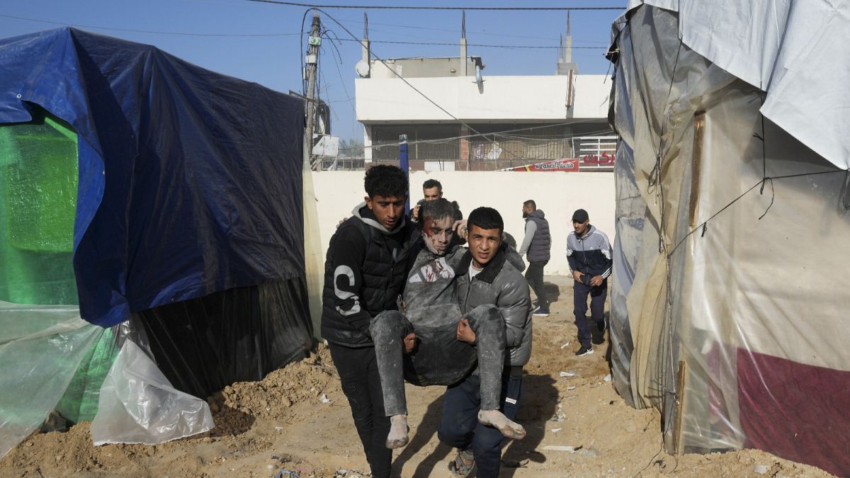Des Palestiniens évacuent un blessé après une frappe israélienne contre un bâtiment à Deir al-Balah, dans la bande de Gaza, le 10.01.2023