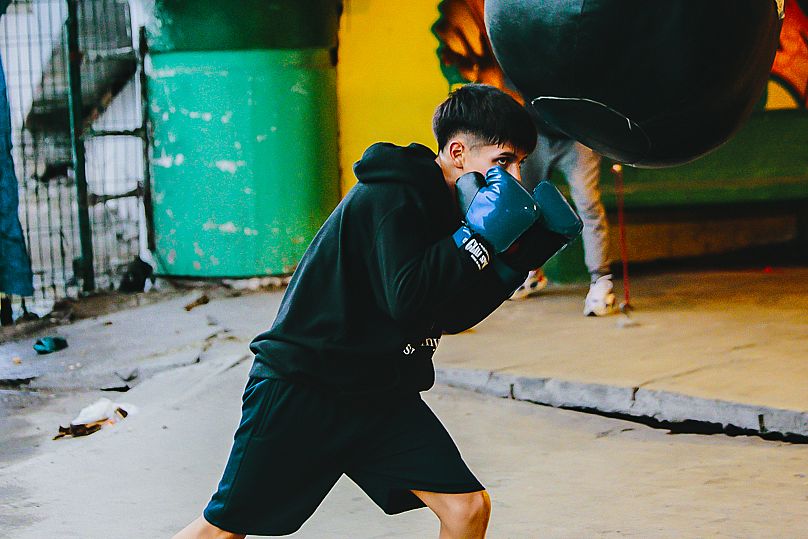 A young fighter trains with a punch bag in Gym Ramirez, Ecatepec de Morelos, Mexico