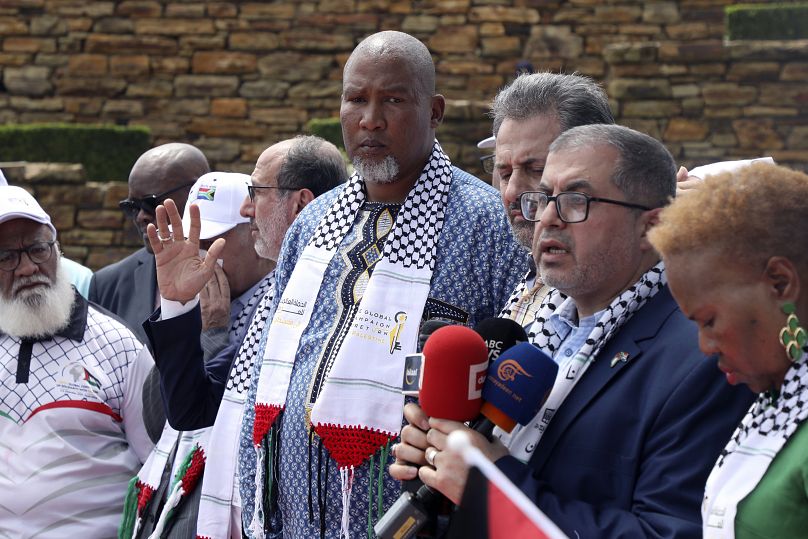 نوه نلسون ماندلا (وسط) در کنار اعضای حماس در دهمین سالمرگ نلسون ماندلا به تاریخ پنجم دسامبر ۲۰۲۳