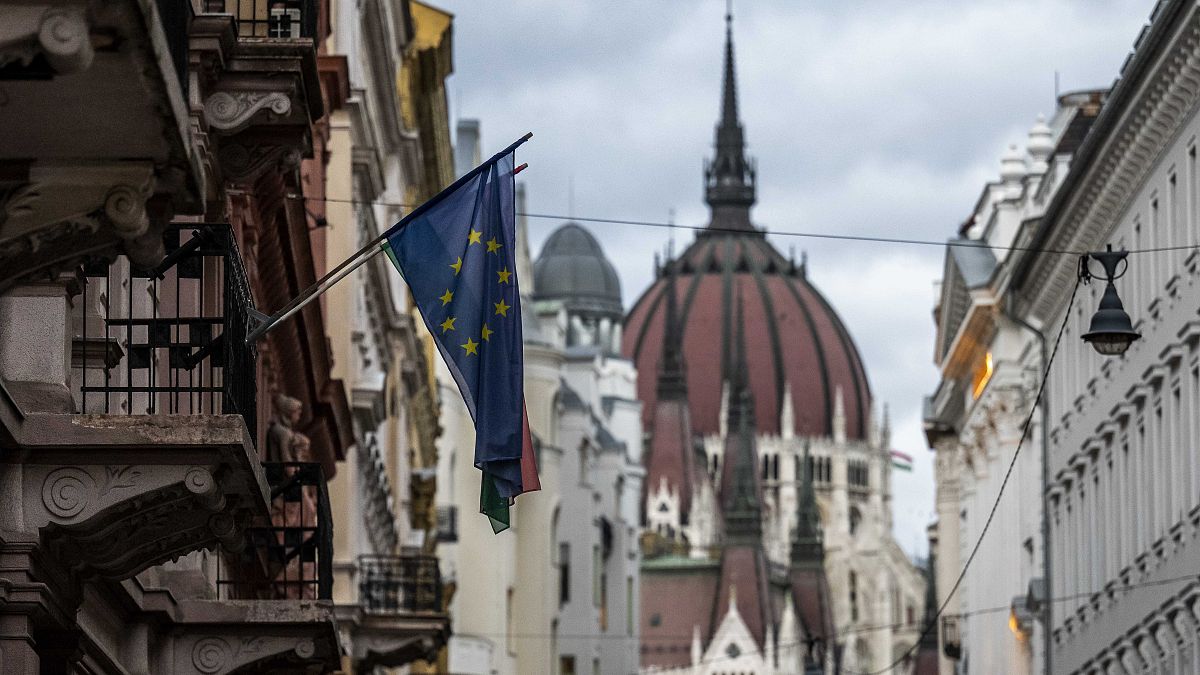 Az Európai Unió zászlaja egy budapesti belvárosi épületen, a háttérben a Parlamenttel 2023. november 20-án