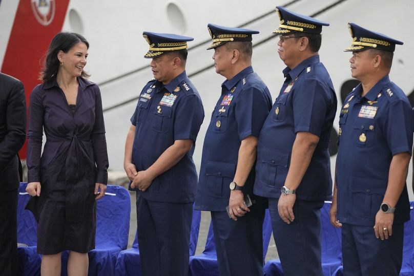 German Foreign Minister Annalena Baerbock, left, talks with Philippine Coast Guard Commandant Admiral Ronnie Gil Gavan, second from left, and other officers during her visit