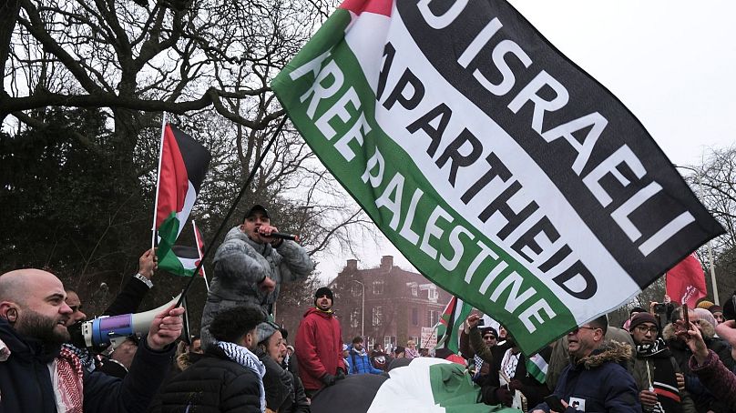 معترضان با پرچم‌های فلسطین در راهپیمایی در مقابل دیوان بین‌المللی دادگستری در لاهه، هلند، پنجشنبه ۱۱ ژانویه.