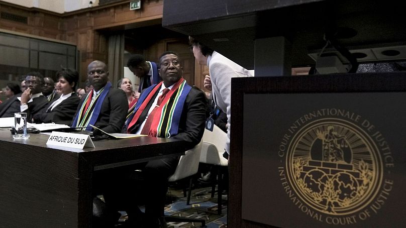 سفیر جمهوری آفریقای جنوبی در هلند (سمت راست)، و وزیر آفریقای جنوبی (وسط) در جریان افتتاحیه جلسات دادگاه بین المللی دادگستری در لاهه
