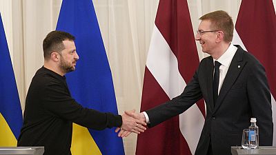 El presidente de Letonia, Edgars Rinkevics, a la derecha, y el presidente ucraniano,  Zelenski, se dan la mano tras su rueda de prensa conjunta en Riga, Letonia