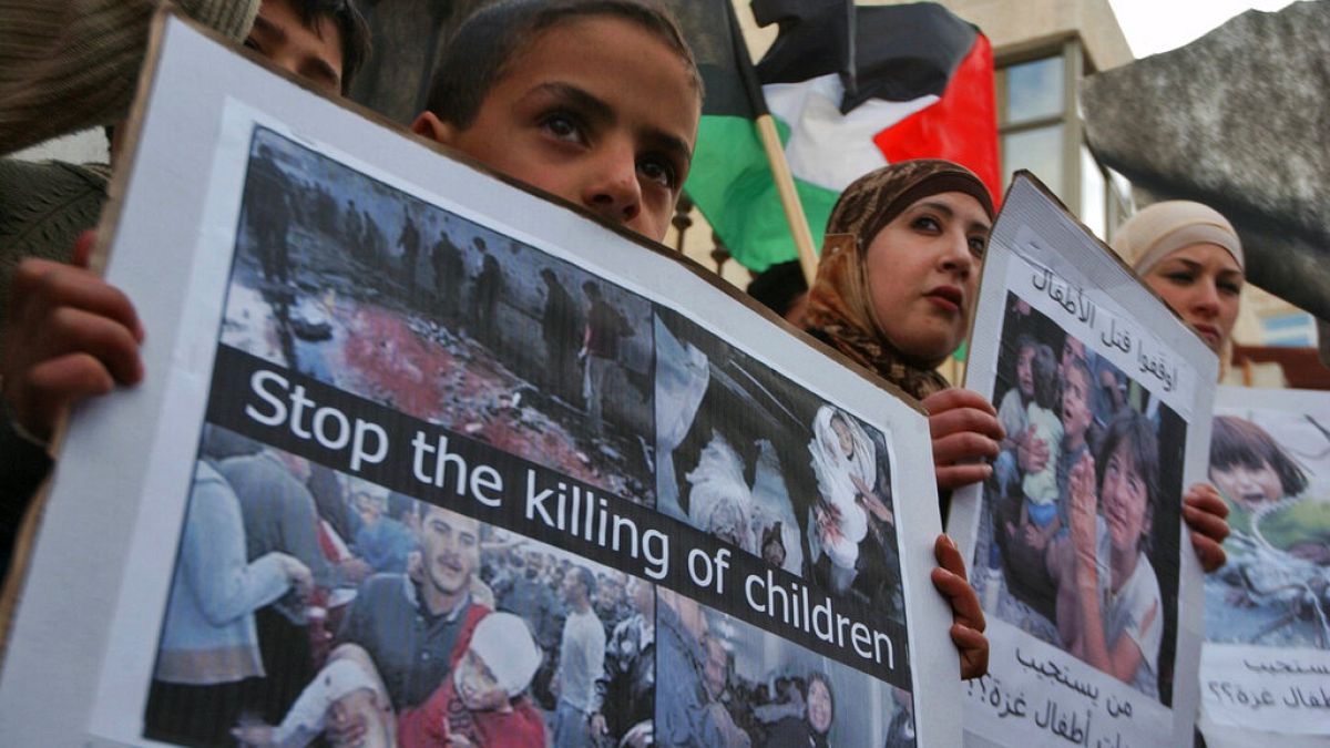 Elinde İngilizce 'Çocuk ölümlerini durdurun' yazılı pankart taşıyan Filistinli çocuk (Arşiv-3 Mart 2008)
