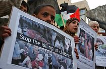 Elinde İngilizce 'Çocuk ölümlerini durdurun' yazılı pankart taşıyan Filistinli çocuk (Arşiv-3 Mart 2008)