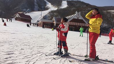 A mother and her daughter take a rest on the slopes at the Masik Pass ski resort in North Korea on Jan. 28, 2018. 
