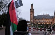 یک طرفدار فلسطینیان در مقابل ساختمان دادگاه در لاهه به تاریخ دوازدهم ژانویه ۲۰۲۴