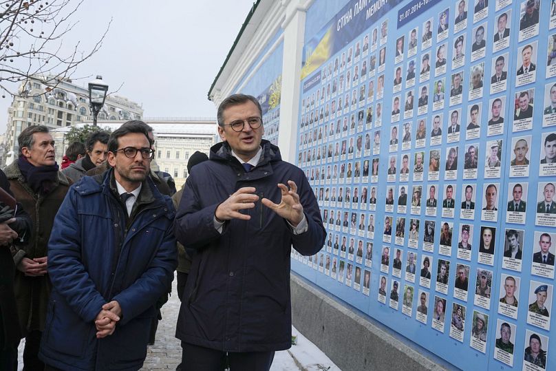 Ukraine's Foreign Minister Dmytro Kuleba, right, and his French counterpart Stephane Sejourne, centre left, visit the Memory Wall of Fallen Defenders of Ukraine in Kyiv