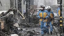 أعوان أمن في عملية بحث في موقع حريق كبير وقع في أعقاب زلزال في واجيما، محافظة إيشيكاوا