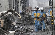 أعوان أمن في عملية بحث في موقع حريق كبير وقع في أعقاب زلزال في واجيما، محافظة إيشيكاوا