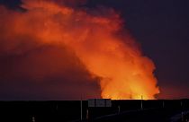 İzlanda'nın Grindavík kentine giden yol olan Suðurstrandavegur'dan patlayan yanardağdan çıkan lavların aydınlattığı gaz bulutunun görünümü, 14 Ocak 2024 Pazar