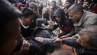 Palestinians evacuate a wounded man after an Israeli strike in Kahan Younis, Gaza Strip