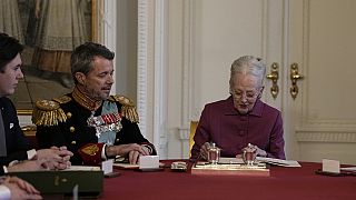 Margarida II assina o documento de abdicação na presença do filho, novo Rei da Dinamarca