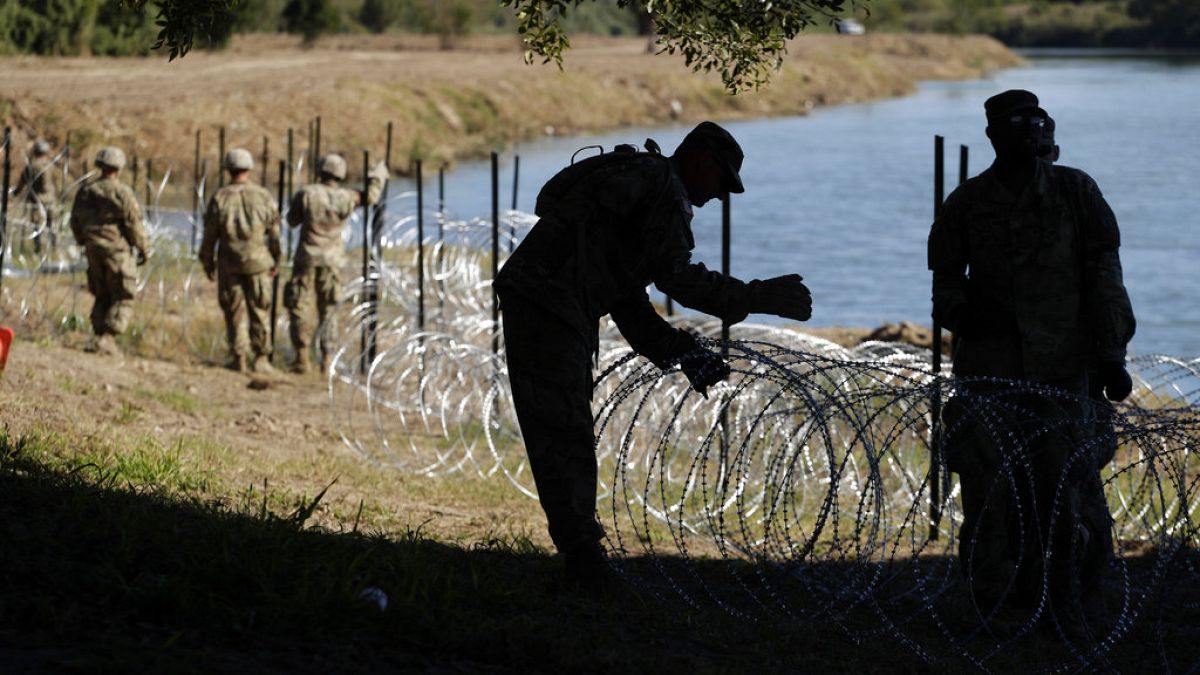 ABD'nin Teksas eyaleti ile Meksika sınırında yer alan Rio Grande Nehri boyunca tel örgü çeken ABD'li askerler (arşiv)