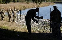 ABD'nin Teksas eyaleti ile Meksika sınırında yer alan Rio Grande Nehri boyunca tel örgü çeken ABD'li askerler (arşiv)