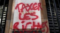 Граффити с надписью "Обложите богатых налогом" на фасаде Национального французского банка во время демонстрации в Париже, 13 апреля 2023 года