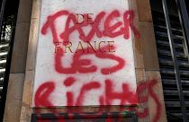 A graffiti reads "Tax the richs" onto the facade of the national French Bank" during a demonstration Thursday, April 13, 2023 in Paris.