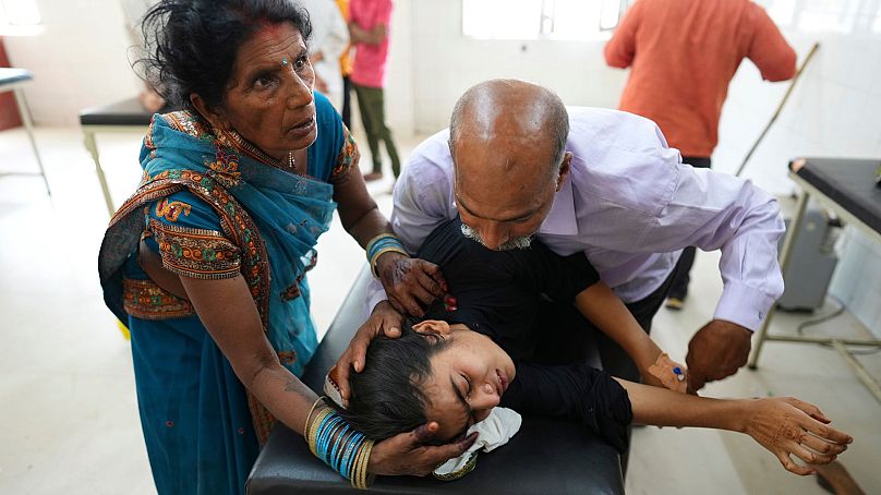 Un père tente de conforter sa fille souffrant de la chaleur à l'hôpital de Ballia, dans l'État d'Uttar Pradesh, en Inde, en juin 2023.